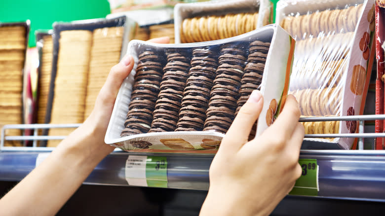 woman selecting cookies off shelf
