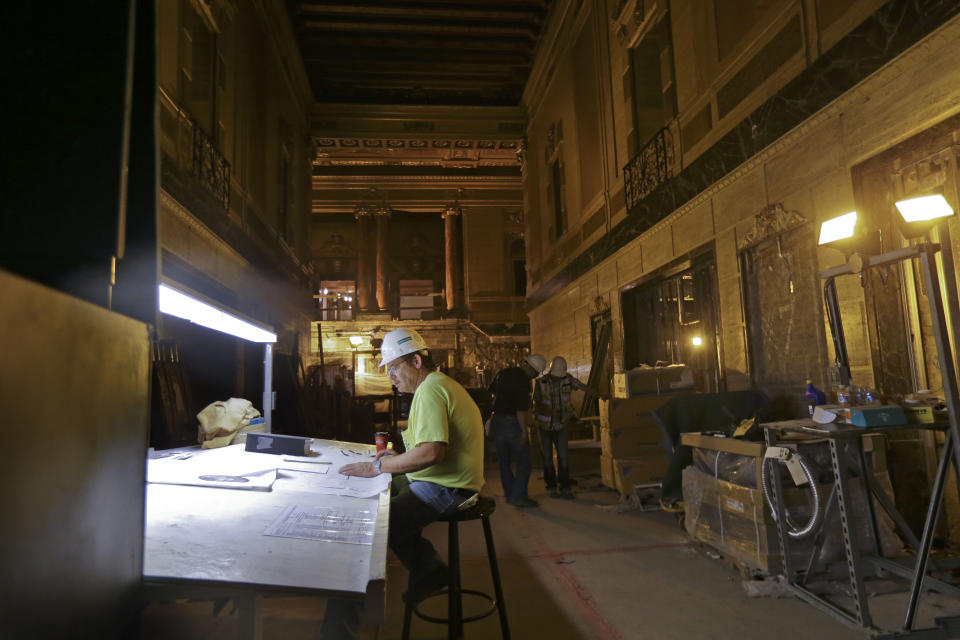 Robert Junker, a construction superintendent, looks over plans as workers perform renovation work at the Saenger Theater in Downtown New Orleans on Wednesday, May 22, 2013. (AP Photo/Gerald Herbert)