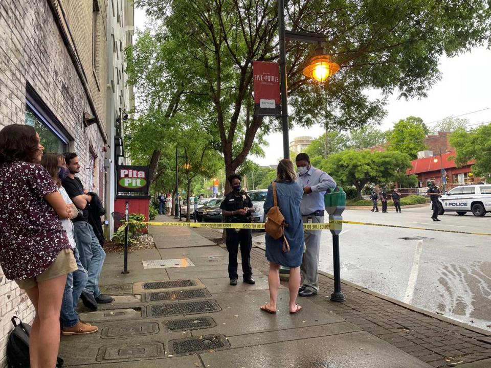 Rachel Ponder speaks with a Columbia police investigator about a shooting in Columbia’s Five Points on Greene Street.