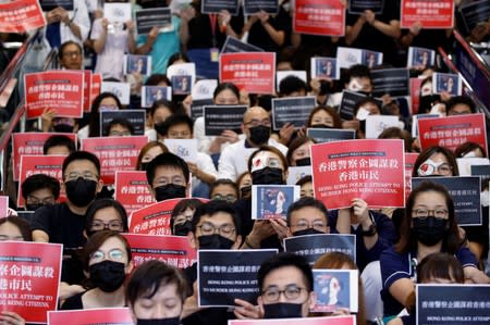 Medical staff hold placards during a picket denouncing police brutality during recent anti-government protests, at Queen Elizabeth Hospital in Hong Kong