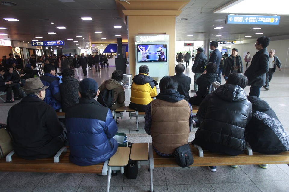 People watch a TV news report with images of Russia's Adelina Sotnikova, left, and South Korea's Yuna Kim about the result of the women's free skate figure skating final during the 2014 Winter Olympics, at the Seoul Railway Station in Seoul, South Korea, Friday, Feb. 21, 2014. South Koreans still love Kim. The judges, however, are another matter. Yuna Kim, known as the "Queen" in South Korea, finished with the figure skating silver medal at the Sochi Olympics behind Adelina Sotnikova of Russia. That left many South Koreans furious over what they saw as questionable judging. (AP Photo/Ahn Young-joon)