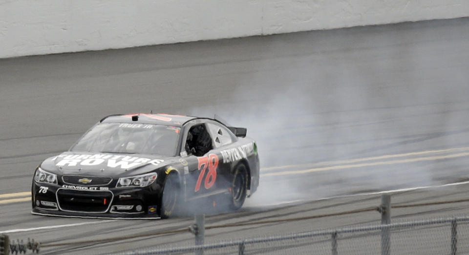 Smokes billows from the car of Martin Truex Jr. during the NASCAR Daytona 500 Sprint Cup series auto race at Daytona International Speedway in Daytona Beach, Fla., Sunday, Feb. 23, 2014. (AP Photo/John Raoux)
