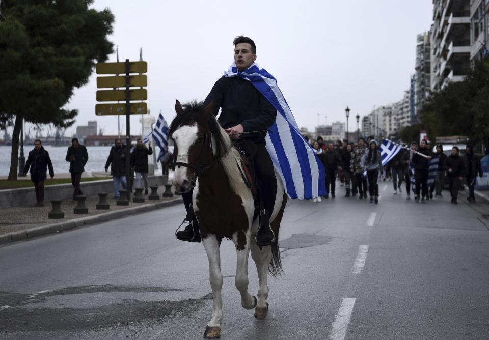 A young horseman draped in a Greek flag, leads a protest in the northern Greek city of Thessaloniki, Thursday, Nov. 29, 2018. About 1,000 high school students protested against government efforts to end a three-decade-old dispute with neighboring Macedonia. (AP Photo/Giannis Papanikos)