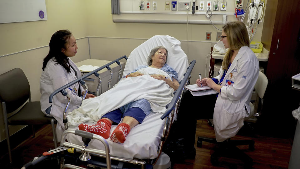 Nurses Lisa Lui-Popelka, left, and Emily Ruben, right, talk with Northwestern Memorial Hospital patient Carol Wittwer at her bedside in a special wing of the Emergency Department in Chicago on Jan. 10, 2018. Popelka and Ruben are specially trained to treat older patients and, when possible, arrange help for them at home. That prevents unneeded hospital admissions and a host of potential problems that can make older patients sicker. (AP Photo/Teresa Crawford)