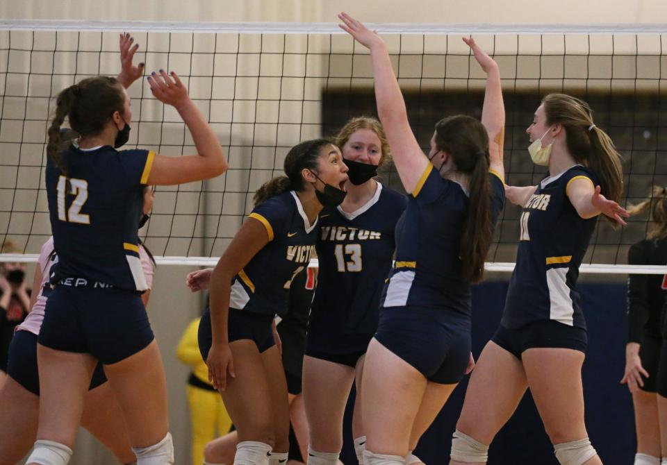 Victor's Alex McKenzie (3), center, celebrates with teammates after her kill for a point during the second set during their Section V Class AA championship finals match up Saturday, Nov. 6, 2021 at Gates Chili High School.  