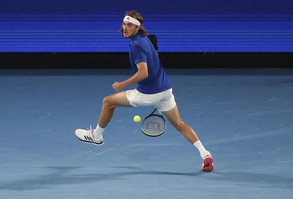 Greece's Stefanos Tsitsipas plays the ball back between his legs in his doubles match with compatriot Michail Pervolarakis against Australia's John Peers and Luke Saville in their ATP Cup match in Melbourne, Australia, Wednesday, Feb. 3, 2021. (AP Photo/Hamish Blair)