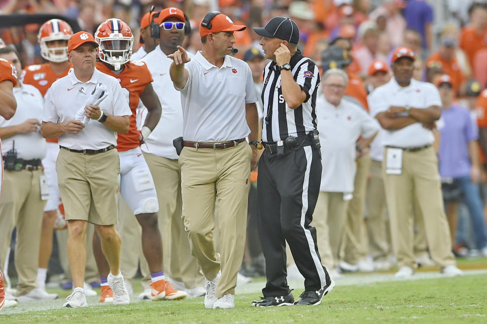Clemson head coach Dabo Swinney, center, discusses a call with an official during the first half of an NCAA college football game against Florida State Saturday, Oct. 12, 2019, in Clemson, S.C. (AP Photo/Richard Shiro)