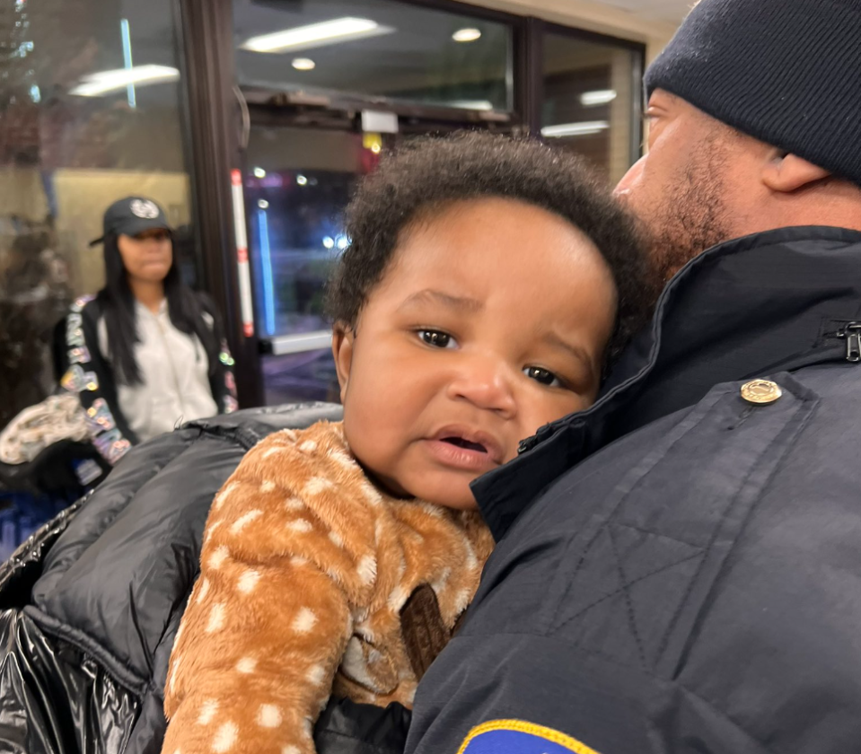 Sgt. Shawn Anderson holds baby Kason Thomas in an Indianapolis Papa Johns location after the missing Columbus, Ohio, twin was safely found in a car outside the restaurant Dec. 22, 2022. Standing in the background is Shyann Belmar, who helped police find Thomas and his suspected kidnapper. Mecka Curry said she snapped the image.