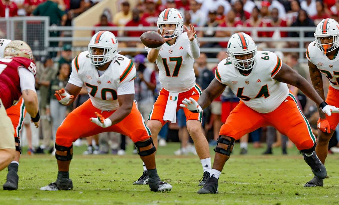 Miami Hurricanes quarterback Emory Williams (17) takes a snap as offensive linemen Javion Cohen (70) and Jalen Rivers (64) block during the game against the Florida State Seminoles during the first half at Doak Campbell Stadium in Tallahassee on Saturday, November 11, 2023.