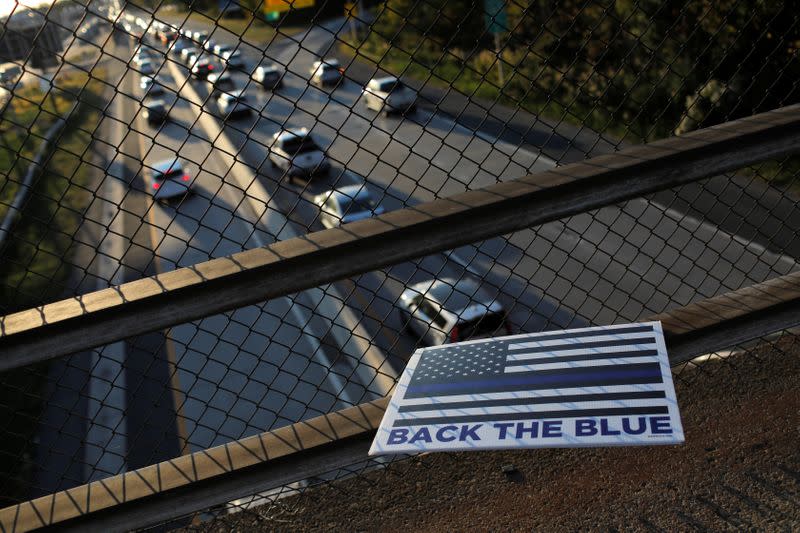 A "Back the Blue" sign in support of police is seen stuck to a fence over a roadway on Staten Island in New York City