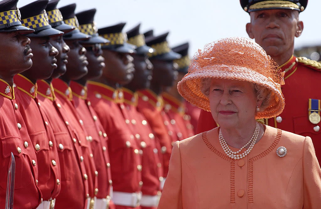 Queen Elizabeth II inspects a guard of honor of the Jamaica Defense Force during her Jubilee tour in Kingston, Jamaica, on February 18, 2002. (Photo by Tim Graham Photo Library via Getty Images)