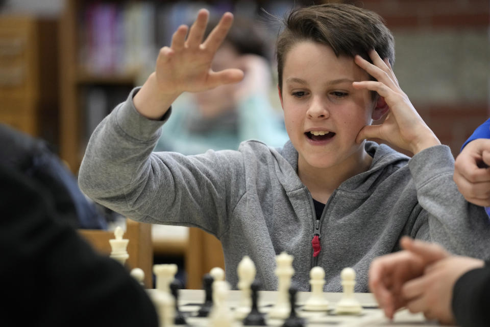 Eli Marquis, a Reeds brook Middle school student, reacts during an after-school chess team match, Tuesday, April 25, 2023, in Hampden, Maine. Part-time chess coach and full-time custodian David Bishop led his elementary and middle school teams to state championship titles this year. (AP Photo/Robert F. Bukaty)