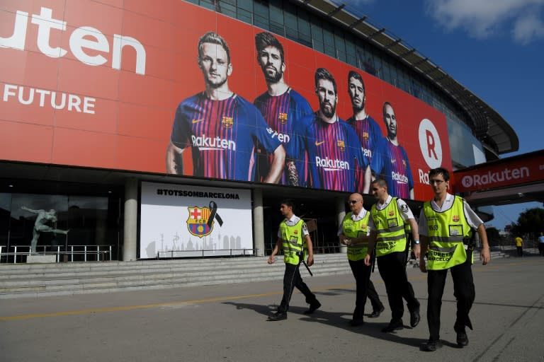 Security members of the Camp Nou stadium walk before the Spanish league footbal match on August 20, 2017