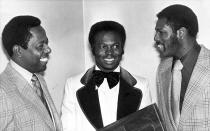 FILE - In this Jan. 28, 1975, file photo, three of the tops in baseball, from left, Hank Aaron, Lou Brock and Bob Gibson talk at an event where they were honored by St. Louis baseball writers in St. Louis. Aaron was honoroed for his 733 home runs and breaking Babe Ruth's record; Brock for his 118 stolen bases in one season and Bob Gibson for passing the National League strikeout record. In the 1970s, players of color finally stepped into an unfettered spotlight, the reserve clause ended, free agency began and the players’ union found its voice. (AP Photo/File)