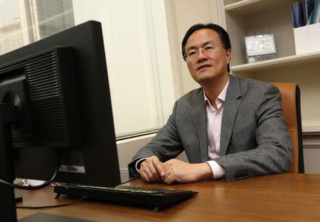 Managing Director of All-Stars Investment Limited Richard Ji poses in front of his desk at his office in Hong Kong January 21, 2015. REUTERS/Bobby Yip