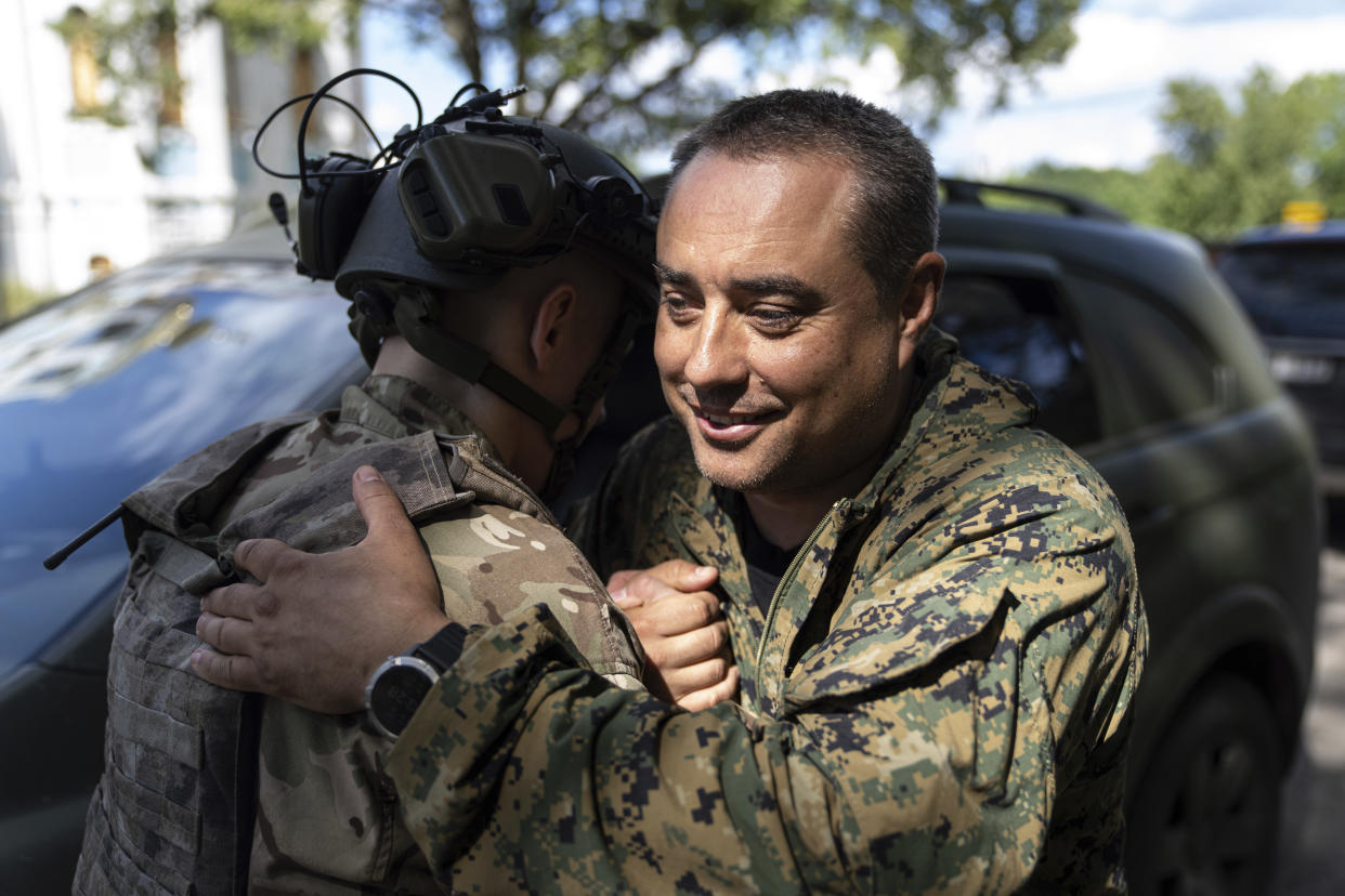 Serhiy Melnyk "Marsel", general of the Ukrainian army, right, hugs a comrade in Kharkiv, Ukraine, Tuesday, July 19, 2022. (AP Photo/Evgeniy Maloletka)