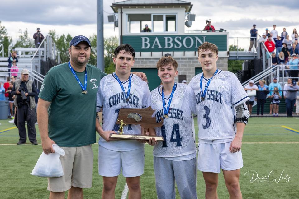 Cohasset High Head Coach Steve Rotondi, Declan Lee, Colin Humphrey, and Luke Willmott hold the Division 4 boys lacrosse state championship trophy.