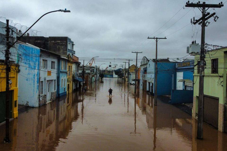 A man wades through an area flooded by heavy rains (AP)