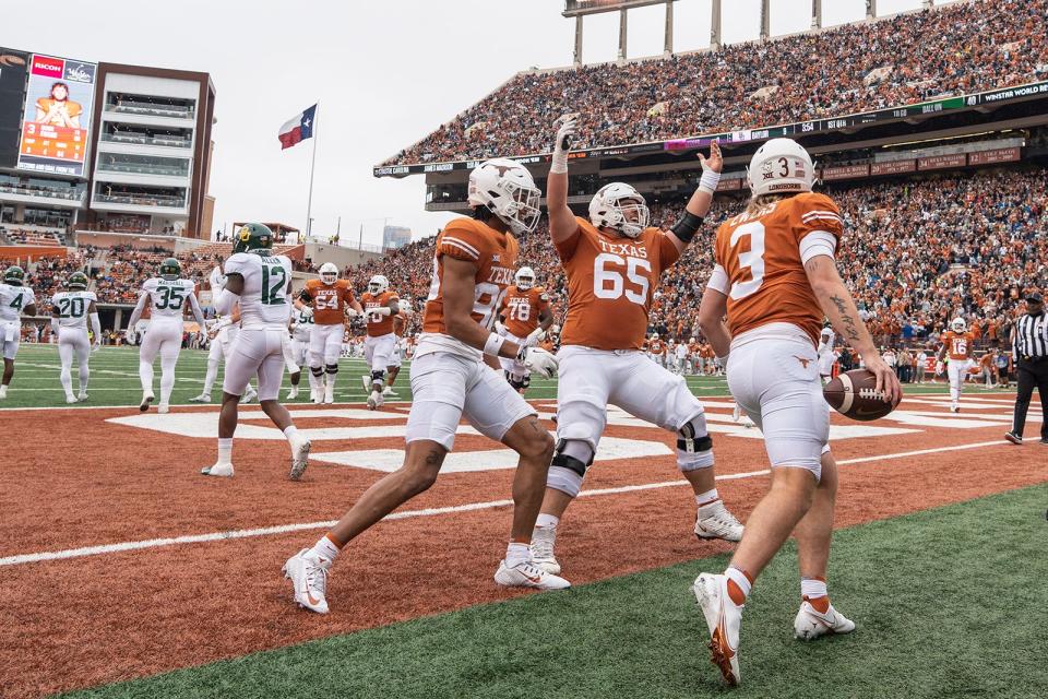 Texas wide receiver Casey Cain, center Jake Majors and quarterback Quinn Ewers celebrate Ewers' first-quarter touchdown in Saturday's 38-27 win over Baylor at Royal-Memorial Stadium. It was Ewers' first rushing score of the season.