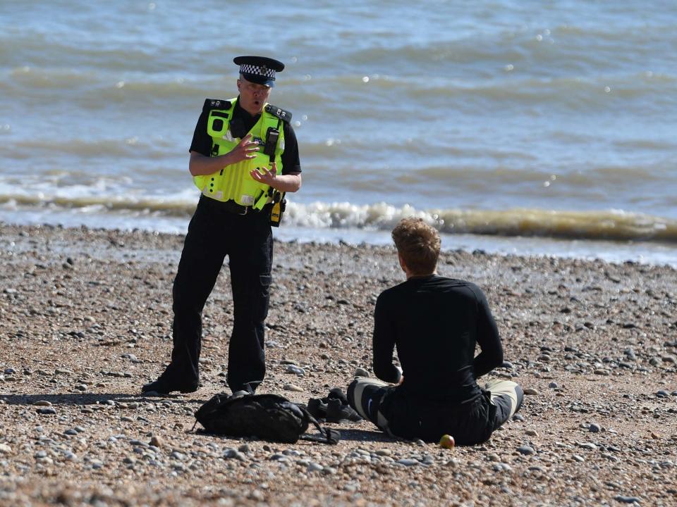 A police officer moves a member of the public off Brighton beach on April 04, 2020: Getty Images