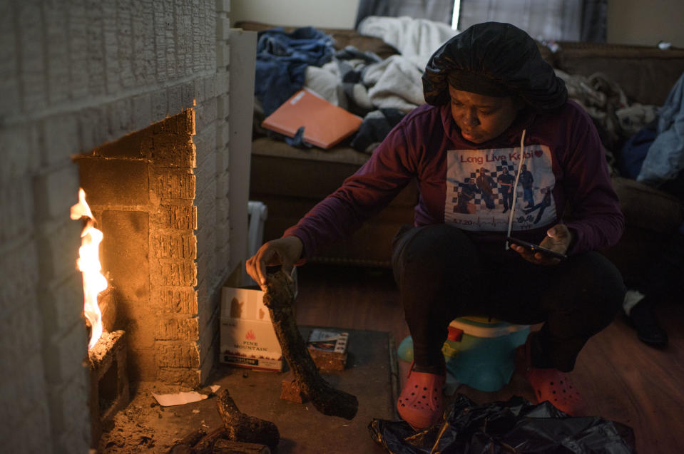 HOUSTON, TX - FEBRUARY 17: Linda McCoy throws wood on a fire for heat in her home in Houston, Texas on February 17, 2021.
(Photo by Mark Felix for The Washington Post via Getty Images)