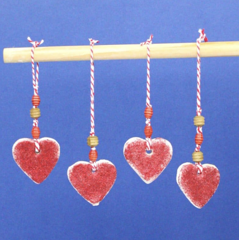 crafts for kids heart salt dough hangers with glitter, hanging from a pole