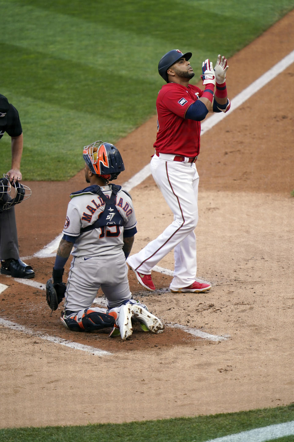 Minnesota Twins' Nelson Cruz, right, celebrates his solo home run off Houston Astros pitcher Jose Urquidy in front of Astros catcher Martin Moldonado in the first inning of a baseball game, Friday, June 11, 2021, in Minneapolis. (AP Photo/Jim Mone)