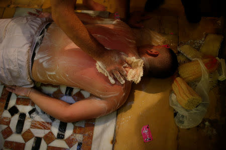 A Palestinian man has his body exfoliated with soap at As-Samra bath house in Gaza City. REUTERS/Suhaib Salem