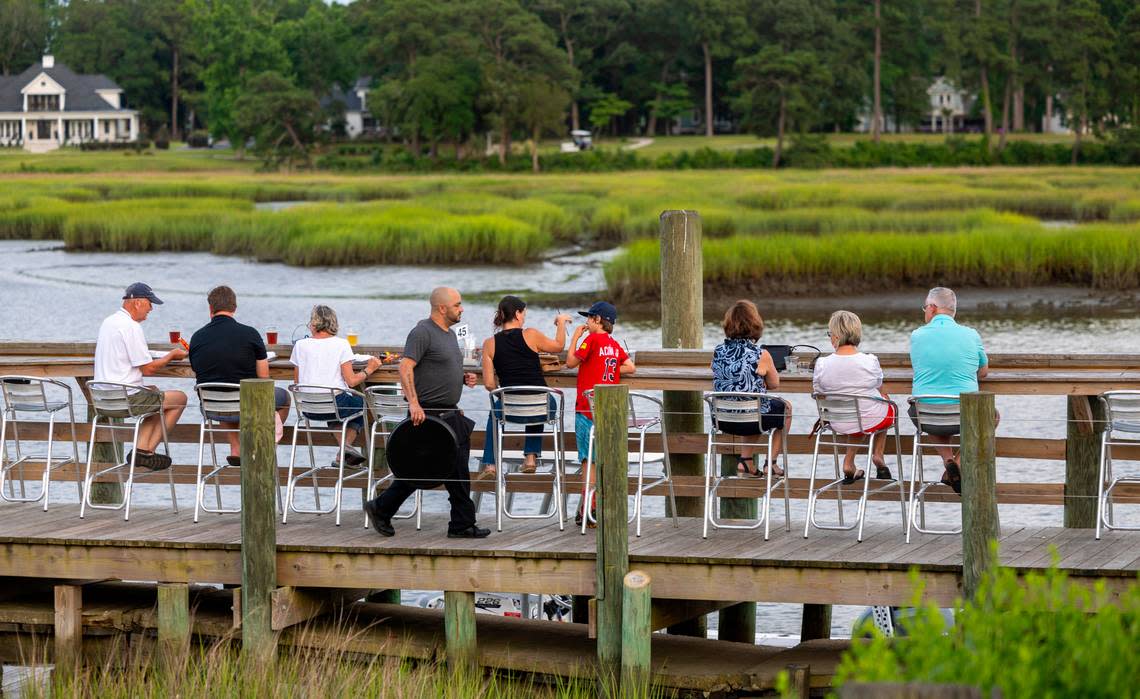 Customers of the Oyster Rock Restaurant dine along the banks of Calabash Creek on Wednesday, July 12, 2024 in Calabash, N.C.