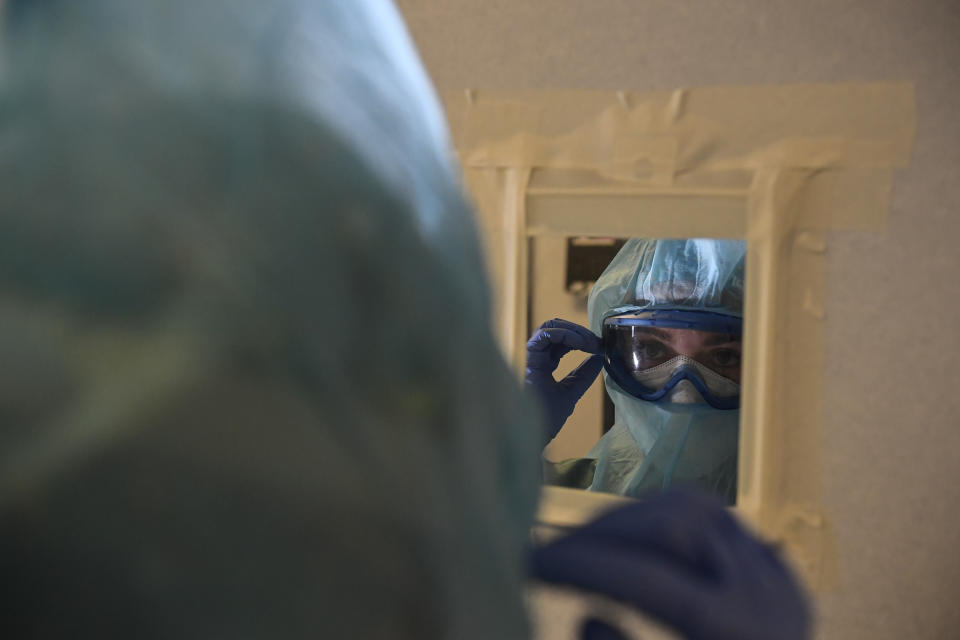 A member of the medical team prepares to treat coronavirus patients in the ICU department of the Clinica Universitaria, in Pamplona, northern Spain, Tuesday, Feb. 2, 2021. Spain's virus expert for the coronavirus pandemic says infections in the country are losing steam but that the contagion curve needs to be bent much further to safeguard the health system. (AP Photo/Alvaro Barrientos)