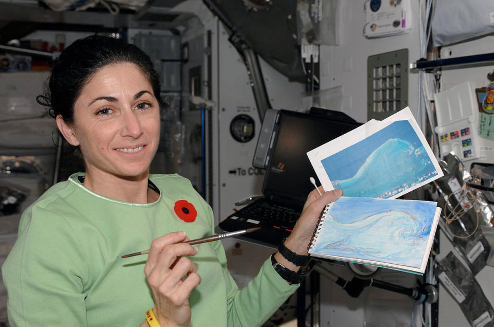 Nicole Stott with her original photo and watercolor painting as she created aboard the space station in 2009. Six years later, Stott left NASA to become a full-time artist.
