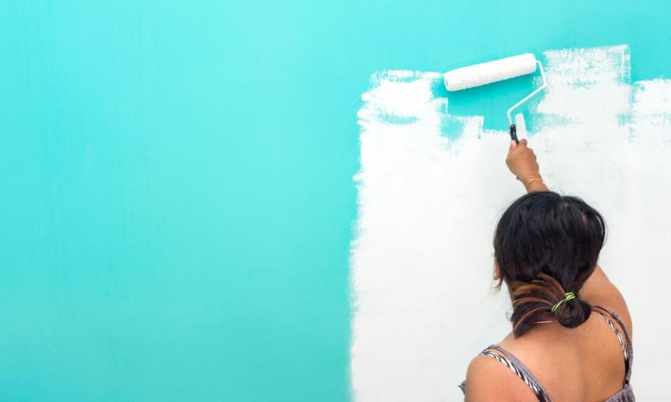 Woman painting a wall with roller