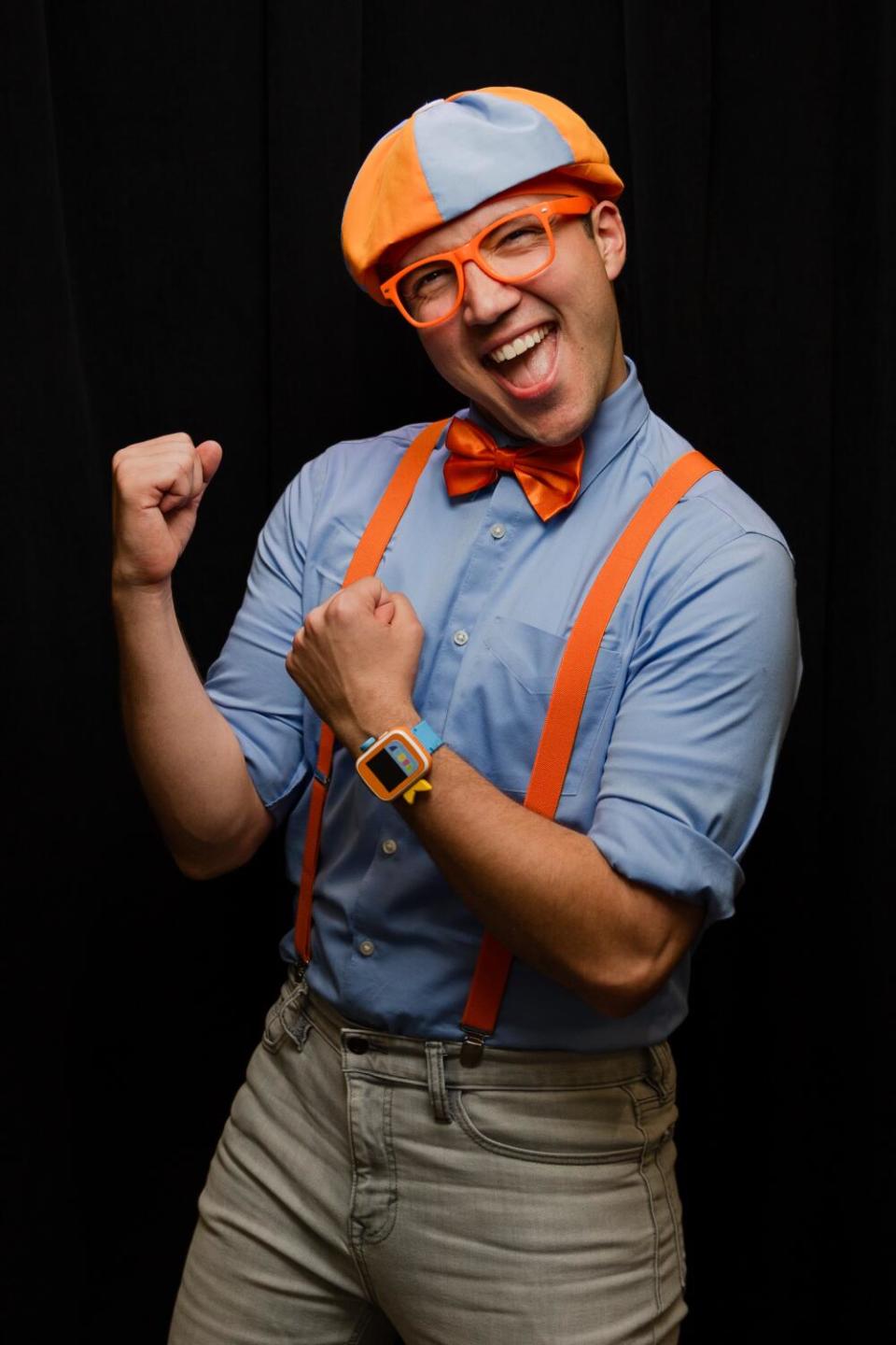 A man stands with his arms raised in a boxing pose.