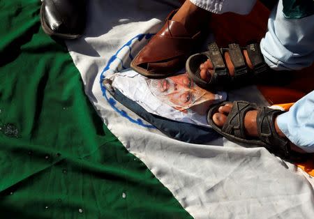 Men step on an Indian flag and a picture of Indian Prime Minister Narendra Modi during a protest against the recent border clashes, in Karachi, Pakistan September 30, 2016. REUTERS/Akhtar Soomro