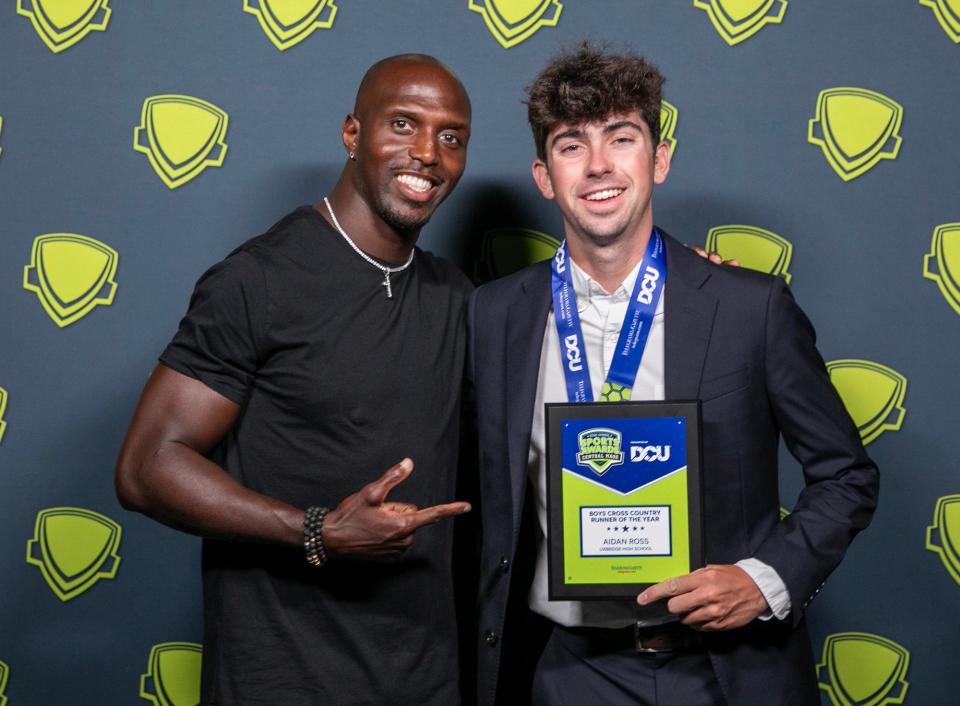 Uxbridge High's Aidan Ross poses with former New England Patriots safety Devin McCourty after receiving his plaque for being named T&G Hometeam Boys' Cross-Country Athlete of the Year during Wednesday's Central Mass. High School Sports Awards at the Hanover Theatre.