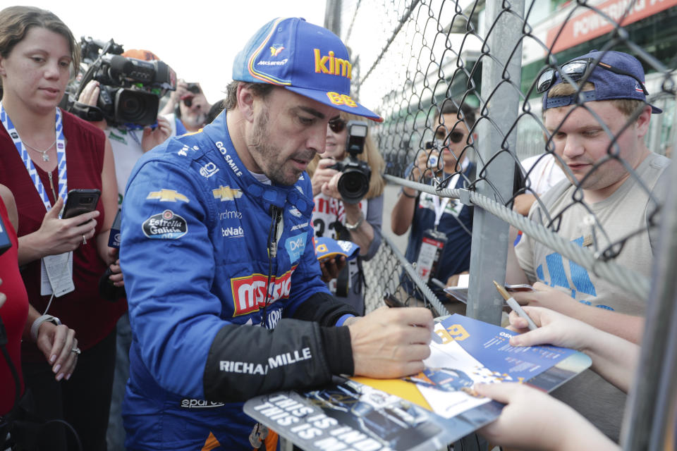 Fernando Alonso, of Spain, stops to sign autographs after qualifications ended for the Indianapolis 500 IndyCar auto race at Indianapolis Motor Speedway, Saturday, May 18, 2019, in Indianapolis. (AP Photo/Michael Conroy)