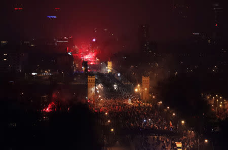 People carry Polish flags and burn flares during a march marking the 100th anniversary of Polish independence in Warsaw, Poland November 11, 2018. Agencja Gazeta/Slawomir Kaminski via REUTERS