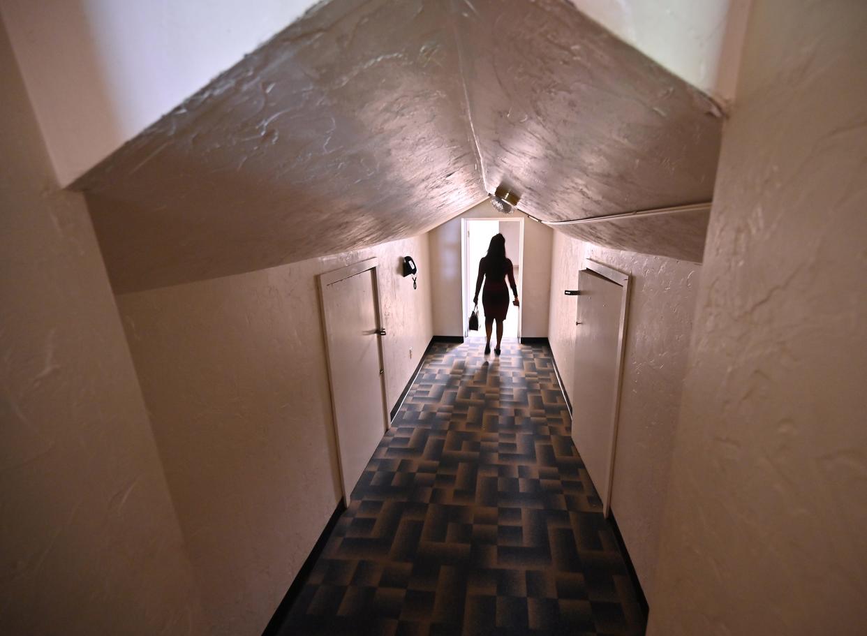 A potential bidder walks through at narrow upstairs hallway at 997 Main St. in Leicester.