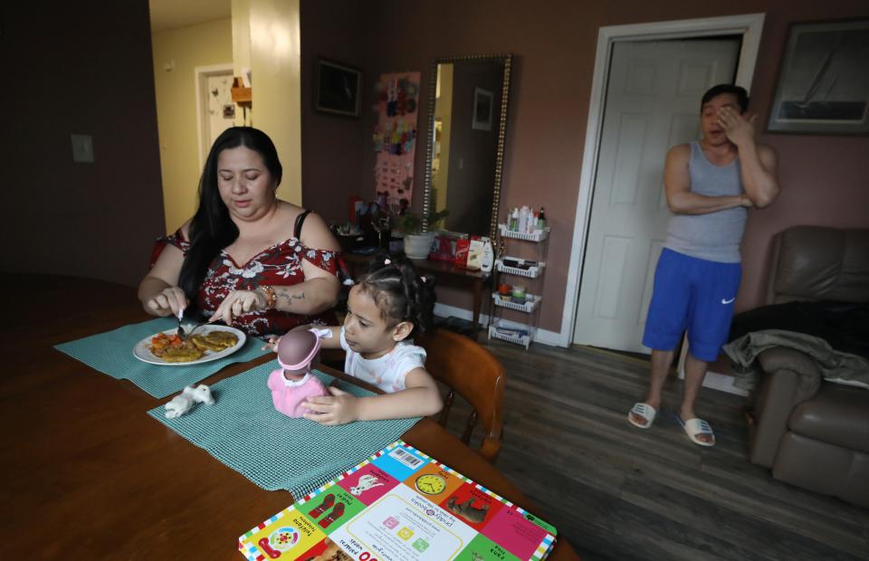 Soody Martinez cuts up the food for her daughter Ashely, 3, who had just come home from her pre-kindergarten class, as her tired husband Joslyn Berrios, who had worked a overnight janitorial shift, joins the family in the dining room of their apartment in Rochester Friday, Jan. 26, 2024.