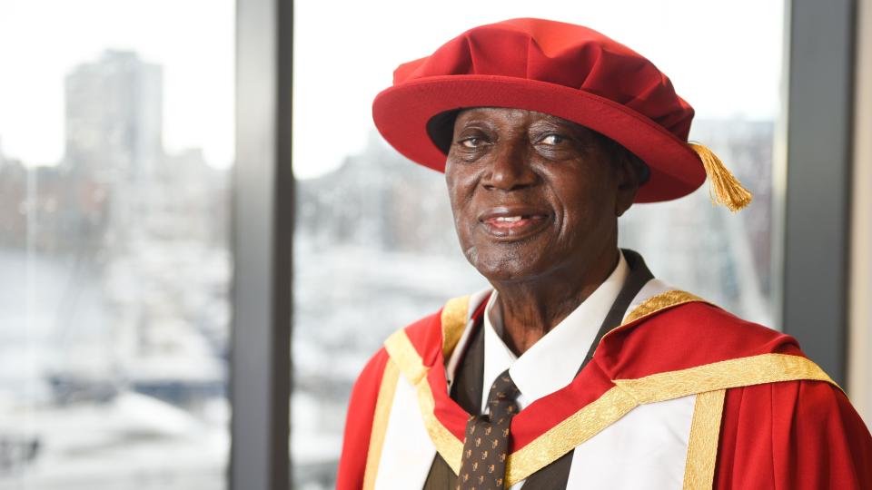 A man in formal red university robes and hat