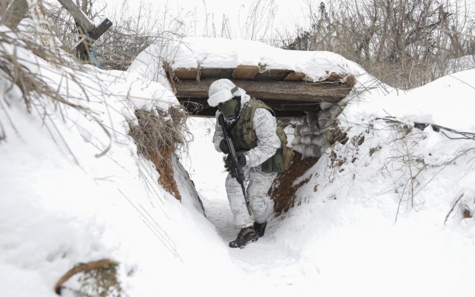 Ukrainian servicemen check the situation at the positions on a front line - STANISLAV KOZLIUK/Shutterstock