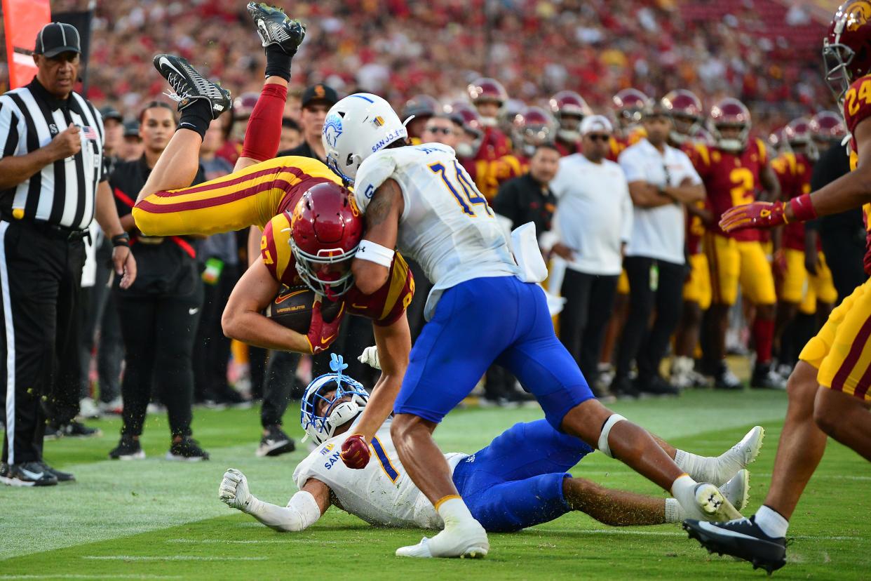 USC tight end Lake McRee, left, is upended on a hit by San Jose State linebacker Elijah Wood during the Trojans' season-opening win on Aug. 26. McRee, a sophomore from Westlake, caught 26 passes this season heading into the Dec. 27 Holiday Bowl.