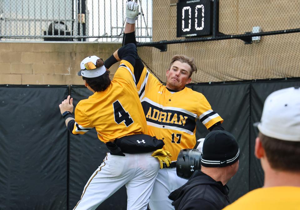 Adrian College's Ryan Davis (17) and Jakob Charles celebrate after Davis' grand slam during Thursday's game against Alma.