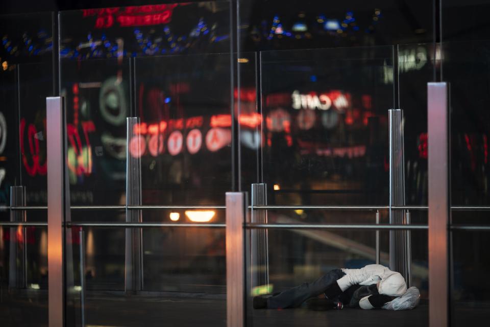 A homeless person sleeps on an overpass along the Las Vegas Strip, Wednesday, Nov. 11, 2020. Las Vegas sells itself on fantasies of wealth, luxury, and sex. The reality feels more like a mixture of the endless mall and Disney-ish resort set to the music of amplified slot machines. (AP Photo/Wong Maye-E)