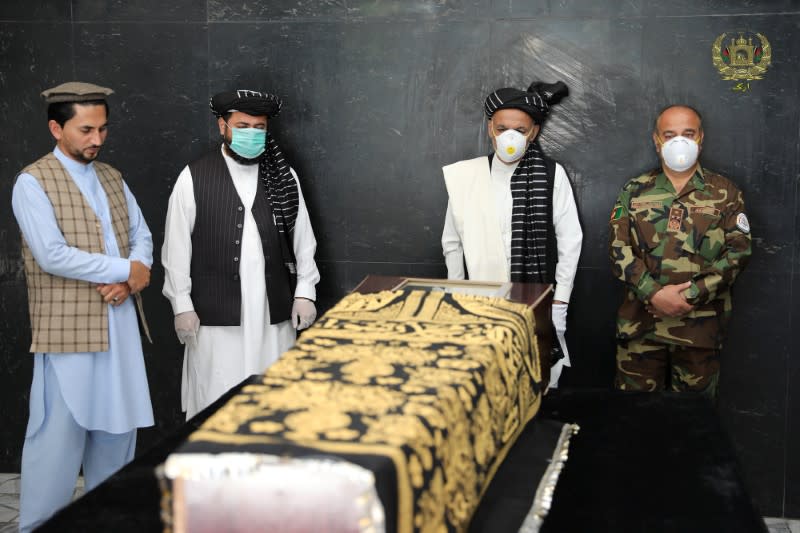 Afghanistan's President Ashraf Ghani stands over the coffin of Ayaz Niazi, a well-known scholar, who was killed last night by a bomb blast in Kabul