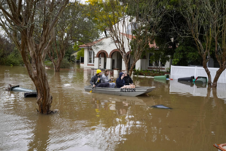 People paddle through a flooded street at Windsor on the outskirts of Sydney, Australia, Tuesday, July 5, 2022. Hundreds of homes have been inundated in and around Australia’s largest city in a flood emergency that was impacting 50,000 people, officials said Tuesday.(AP Photo/Mark Baker)