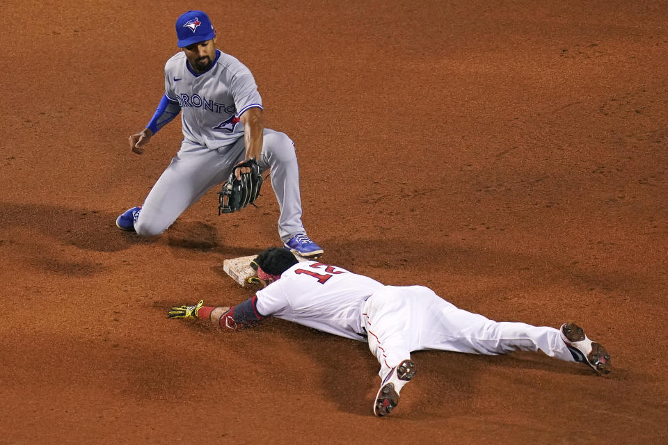 Boston Red Sox's Marwin Gonzalez (12) beats the tag by Toronto Blue Jays second baseman Marcus Semien while sliding into second with a double during the sixth inning of a baseball game at Fenway Park, Wednesday, April 21, 2021, in Boston. (AP Photo/Charles Krupa)