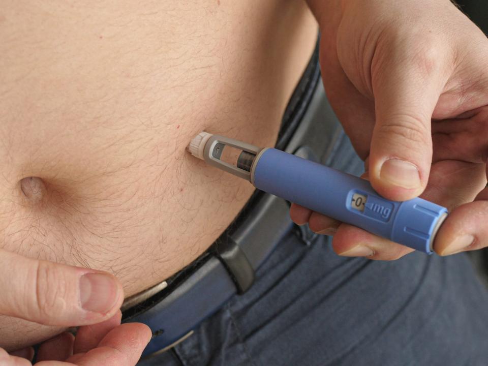 person injecting semaglutide into their belly