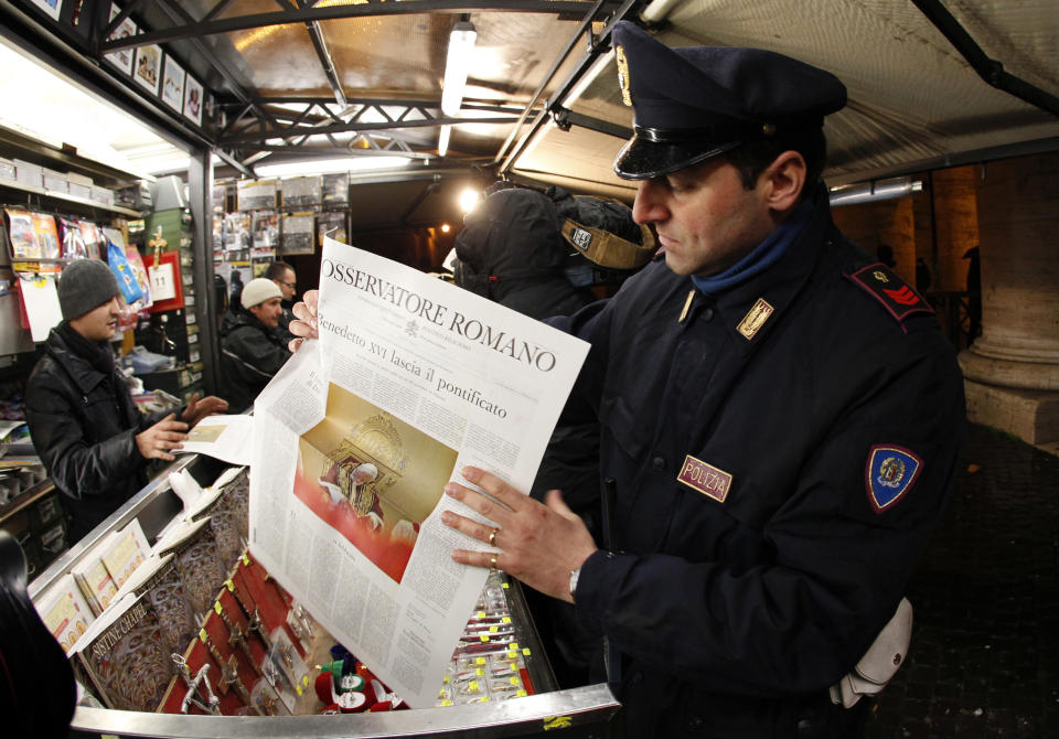 A policeman hold the Osservatore Romano newspaper in Rome