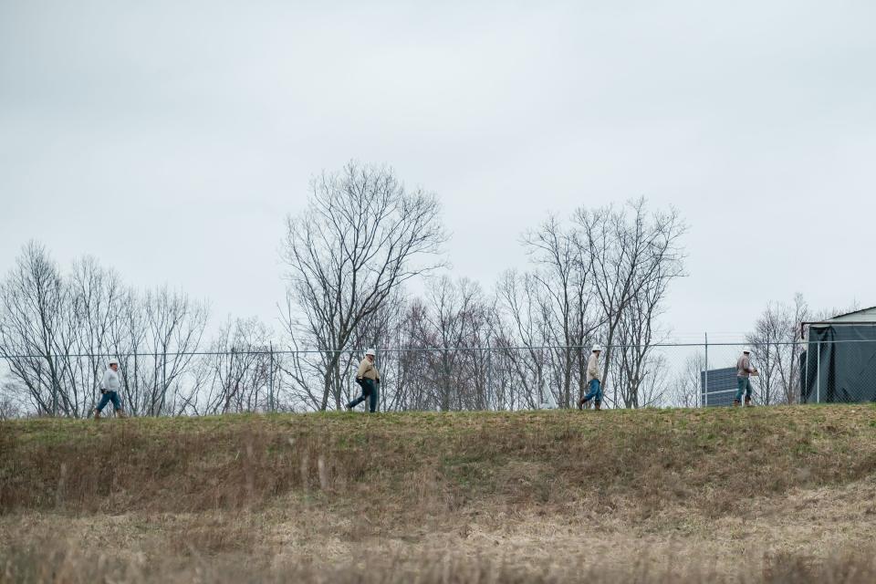 Workers from Encino Energy walk the perimeter of the CHK Jamar Pad owned and maintained by Encino Energy in North Township, Harrison County. An oil wellhead caught fire early Tuesday morning.
